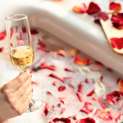 female-hand-holding-a-glass-of-white-wine-while-si-2024-11-29-16-42-26-utc