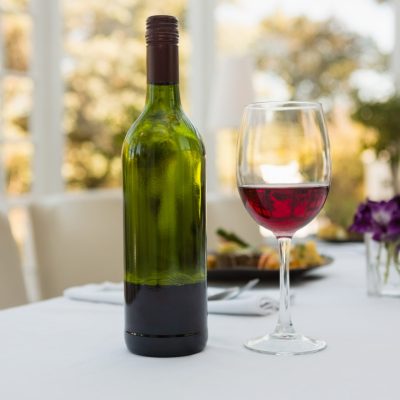 Close up of wineglass and bottle on table in restaurant